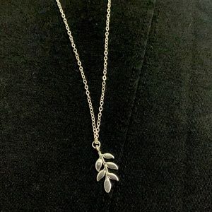 Silver tone necklace with olive branch pendant. 18 in. chain. Lobster claw clasp